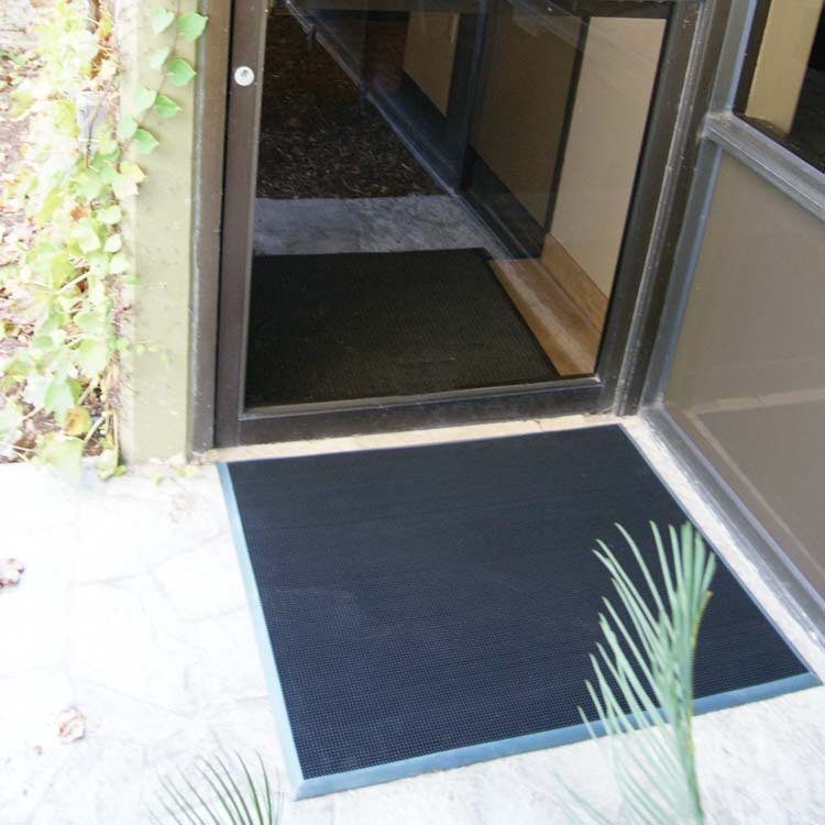 Door Scraper Action Shot 2 Large Doormat with blue border placed in front of door