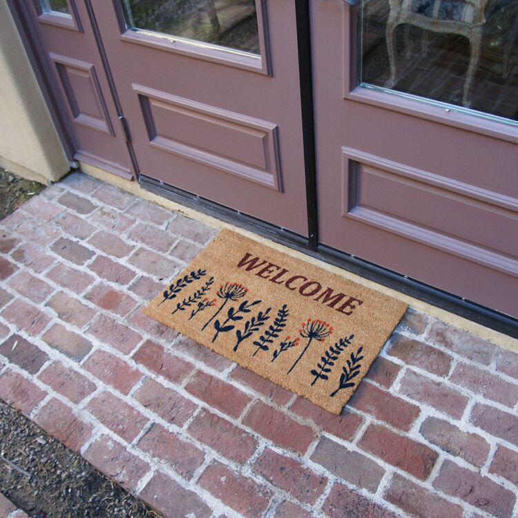 WildflowerMeadow Action 03 750x750 1 Wildflower Meadow Welcome Doormat in front of door