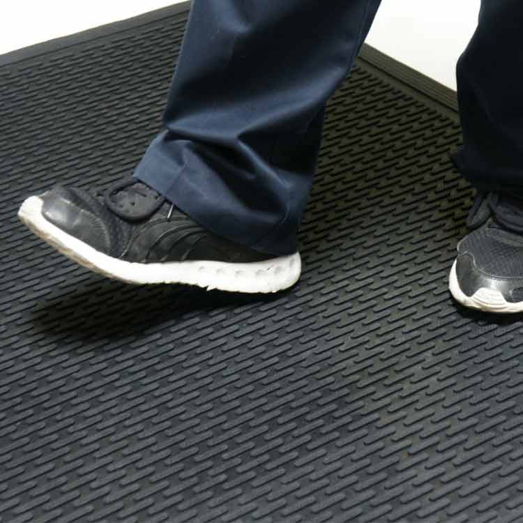 Dura_Scraper_Linear_Action3_Large Black color Ultra-Durable and Economical Rubber Doormat man standing
