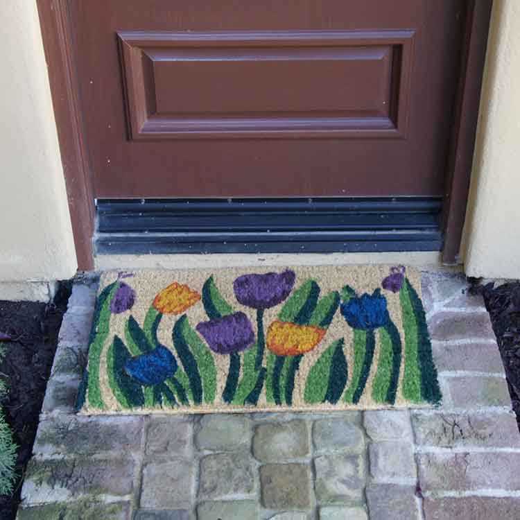 Tulip-04-Action_Large Handmade doormat with tulip garden design in front of dark brown door